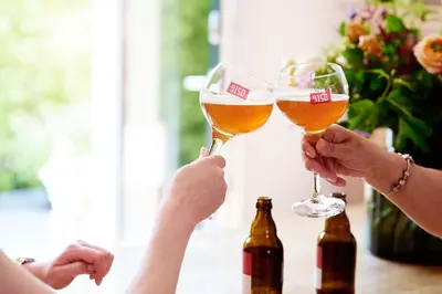 two people are holding glasses of beer at Vakantiewoning De Gulden Sleutels in Kruibeke