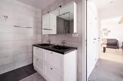 a bathroom with a sink and a mirror at Vakantiewoning De Gulden Sleutels in Kruibeke