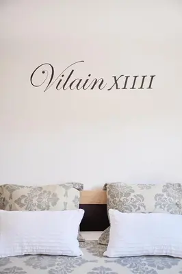 a sign on a wall above a bed with pillows at Vakantiewoning De Gulden Sleutels in Kruibeke