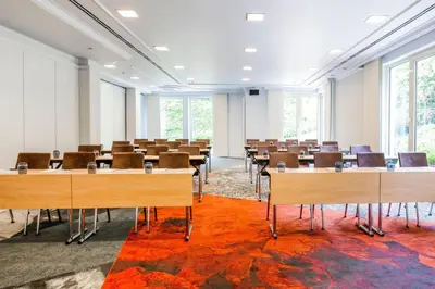 a room with tables and chairs in a room with windows at Marriott Executive Apartments Brussels in Brussels