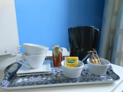 a tray with bowls and cups on a counter at Room Feliz in Zele
