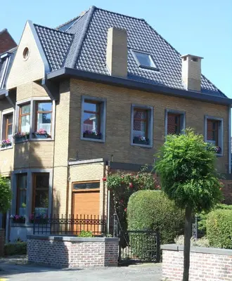 a brown house with a black roof at Room Feliz in Zele
