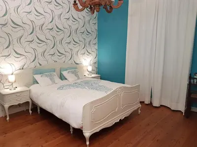 a bedroom with a white bed with two night tables at Room Feliz in Zele