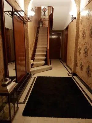 a hallway with a staircase with a black rug at Room Feliz in Zele