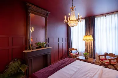a bedroom with a bed and a mirror and a chandelier at Spirella in Brussels