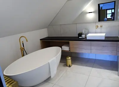 a bathroom with a white tub and a sink at Ask Lily in Westmeerbeek