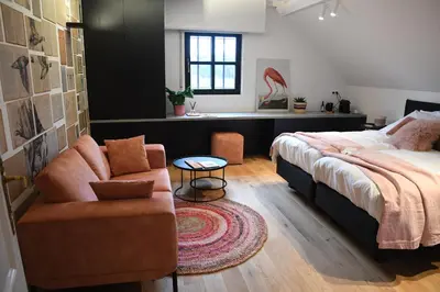 a bedroom with a bed and a couch and a table at Ask Lily in Westmeerbeek