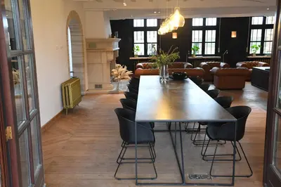 a dining room with a table and leather chairs at Ask Lily in Westmeerbeek