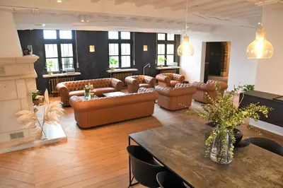 a living room with leather couches and a table at Ask Lily in Westmeerbeek