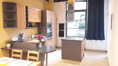 a kitchen with a counter and a table with chairs at CEP MAISONNETTE in Brussels