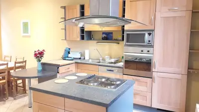 a kitchen with a counter and a table in it at CEP MAISONNETTE in Brussels
