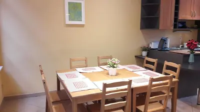 a dining room table with chairs and a kitchen at CEP MAISONNETTE in Brussels