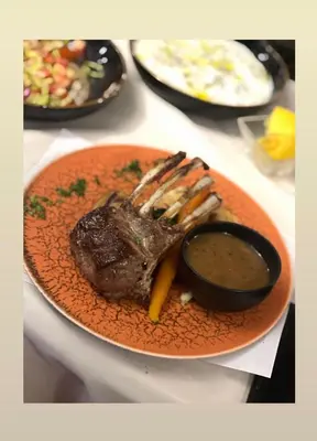 a plate of food with a steak and dipping sauce at Fly inn Hotel Lounge & Nezzo Restaurant in Machelen