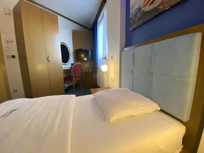 a bedroom with a white bed and a window at Fly inn Hotel Lounge & Nezzo Restaurant in Machelen