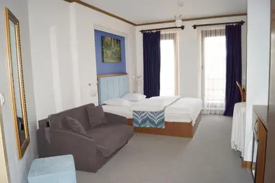 a small room with a bed and a couch at Fly inn Hotel Lounge & Nezzo Restaurant in Machelen