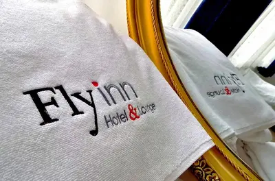 a white shirt with the word ivemia next to a mirror at Fly inn Hotel Lounge & Nezzo Restaurant in Machelen