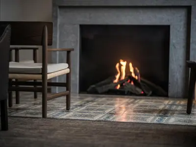 a fireplace with a chair and a fire in it at august in Antwerp