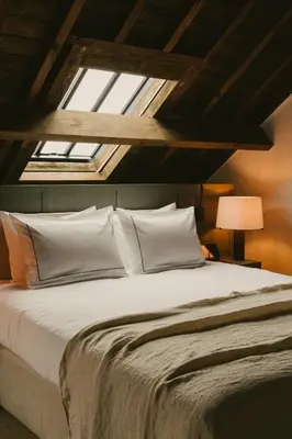 a bedroom with a large bed with a skylight at august in Antwerp