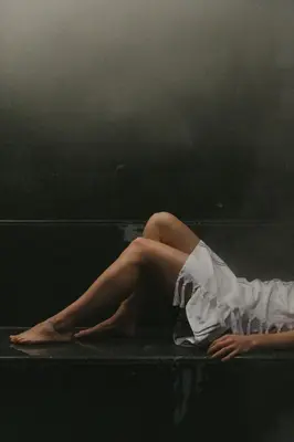 a woman in a white dress laying on a couch at august in Antwerp