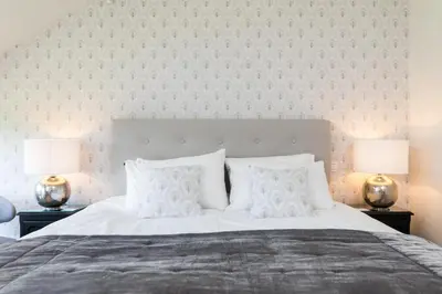 a bedroom with a large white bed with two lamps at Chez Spoons B&B in Bossut-Gottechain