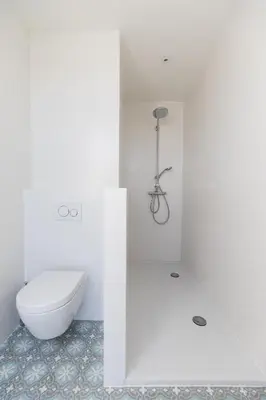 a white bathroom with a toilet and a shower at Chez Spoons B&B in Bossut-Gottechain