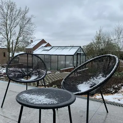 two chairs with snow on them in front of a greenhouse at Chez Spoons B&B in Bossut-Gottechain