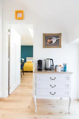 a white dresser in a room with a bedroom at Chez Spoons B&B in Bossut-Gottechain