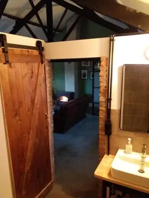 a bathroom with a wooden door and a sink at B&B LoFt 21 in Ravels