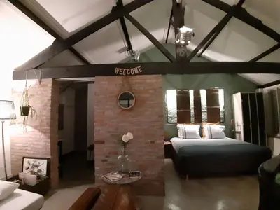 a living room with a couch and a brick fireplace at B&B LoFt 21 in Ravels