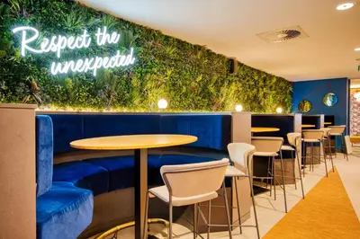 a restaurant with a blue bar with tables and chairs at B&B HOTEL Brussels Centre Louise in Brussels