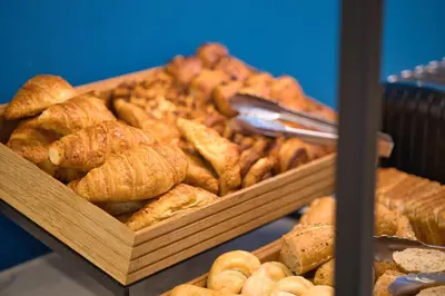 a bunch of different types of breads and pastries at B&B HOTEL Brussels Centre Louise in Brussels