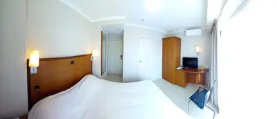 a bedroom with a large white bed and a sink at Hotel De Croone in Ninove