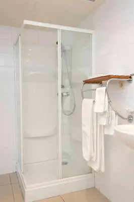 a shower with a glass door in a bathroom at Hotel De Croone in Ninove