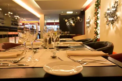 a table with glasses and napkins on a table in a restaurant at Hotel De Croone in Ninove
