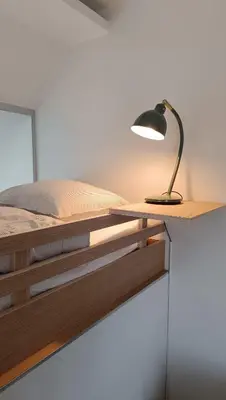 a desk with a lamp on top of a bed at Loftsuite in Ghent
