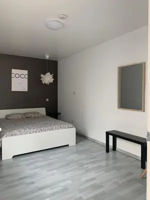 a bedroom with a bed and a table in it at Anna Penthouse in Ghent
