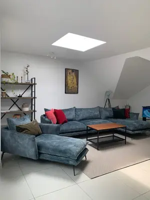 a living room with a blue couch and a table at Anna Penthouse in Ghent