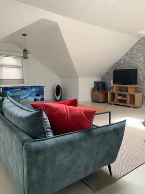 a living room with a gray couch and red pillows at Anna Penthouse in Ghent