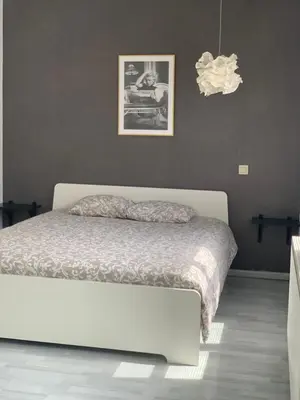 a bedroom with a white bed and a black wall at Anna Penthouse in Ghent