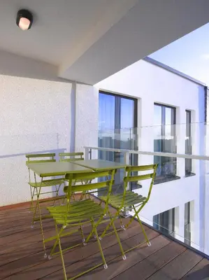 a dining room with a table and chairs on a balcony at Thon Residence Florence Aparthotel in Brussels