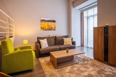 a living room with a couch and a coffee table at Thon Residence Florence Aparthotel in Brussels