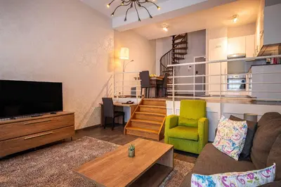 a living room with a couch and a television at Thon Residence Florence Aparthotel in Brussels
