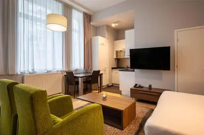 a living room with a couch and a dining room at Thon Residence Florence Aparthotel in Brussels