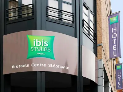 a sign on a building with aubs services sign on it at ibis Styles Hotel Brussels Centre Stéphanie in Brussels