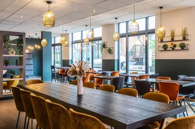 a dining room with a large wooden table and chairs at ibis Styles Hotel Brussels Centre Stéphanie in Brussels