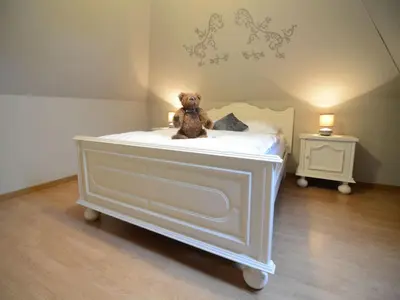 a teddy bear sitting on top of a bed at Holiday Home in Zele near Laarne Castle in Zele