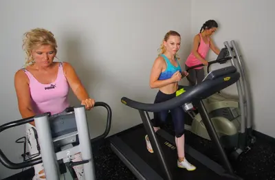 three women on a treadmill in a gym at Best Western Plus Aldhem Hotel in Grobbendonk