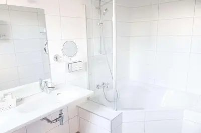 a white bathroom with a shower and a sink at Best Western Plus Aldhem Hotel in Grobbendonk