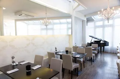 a dining room with tables and a piano at Best Western Plus Aldhem Hotel in Grobbendonk