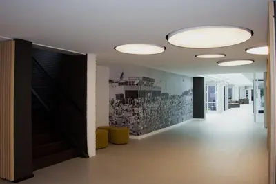a hallway of an office with lights on the ceiling at Let's Meet Elewijt in Elewijt